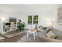 Bright living room featuring hardwood floors, a large window, a comfy couch, and stylish decor at 1208 Manassas Ct # A, Raleigh, NC 27609