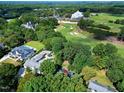 Aerial view showcasing the golf course, mature trees, and surrounding neighborhood with large residential homes at 1217 Briar Patch Ln, Raleigh, NC 27615