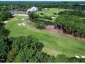 Scenic aerial view of the golf course featuring lush greenery, manicured fairways, and the country club at 1217 Briar Patch Ln, Raleigh, NC 27615