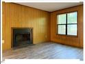 Living room with a brick fireplace and ample natural light from a large window at 125 Forsyth Dr, Chapel Hill, NC 27517