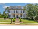Charming two-story home with black shutters, covered porch, swing and manicured lawn at 12500 Richmond Run Dr, Raleigh, NC 27614