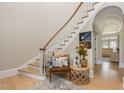 Elegant foyer featuring hardwood floors, staircase, chair and beautiful decor at 12500 Richmond Run Dr, Raleigh, NC 27614