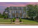 Charming two-story home with a well-manicured lawn, elegant black shutters, and inviting front porch seating at 12500 Richmond Run Dr, Raleigh, NC 27614