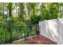 Fenced-in backyard with a combination of black metal and white vinyl fencing, plus a decorative blue heron at 128 Potomac River St, Garner, NC 27529