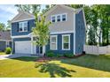 Well-maintained two-story home featuring blue siding, white trim, and a neatly landscaped front yard at 128 Potomac River St, Garner, NC 27529