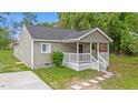 Exterior view of charming home with gray siding, white trim, and inviting front porch at 128 W Parker St, Henderson, NC 27536