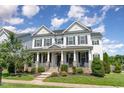 Inviting two-story home featuring a covered front porch and manicured lawn at 1304 Revolution Cir, Raleigh, NC 27603