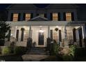 Two-story home at night featuring a covered porch with hanging plants and stone accents at 1304 Revolution Cir, Raleigh, NC 27603