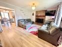 Cozy living room with a brick fireplace, plush gray sofas, and wood-look flooring at 1305 Shakentown St, Knightdale, NC 27545