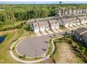 An aerial shot showcases the townhome community's layout, featuring a pond and trees at 136 Ashlar Ct, Cary, NC 27519