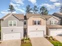View of charming townhomes with attached garages and manicured landscaping at 136 Ashlar Ct, Cary, NC 27519