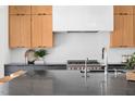 Modern kitchen featuring a large island with a black countertop, stylish wood cabinets, and stainless steel appliances at 1405 Watts St, Durham, NC 27701