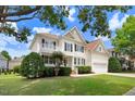 View of a charming two-story home with beautiful landscaping, front porch, and attached two-car garage at 1420 Lagerfeld Way, Wake Forest, NC 27587