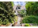Quaint home with a stone pathway leading to the front door, surrounded by lush greenery and trees at 1503 Hollywood St, Durham, NC 27701