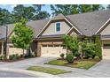 Attractive townhome featuring brick, stone, and shingle exterior with a well-maintained lawn and two-car garage at 192 Glenpark Pl, Cary, NC 27511