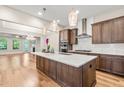 Spacious kitchen with a large island, stylish pendant lights, stainless steel appliances, and hardwood flooring at 192 Glenpark Pl, Cary, NC 27511