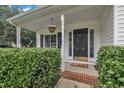 Inviting front porch and door with decorative plantings, columns, and transom windows at 201 Crossfire Rd, Holly Springs, NC 27540