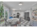 Eat-in kitchen features modern appliances, breakfast area, and black and white tile flooring at 201 Crossfire Rd, Holly Springs, NC 27540