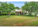 Traditional home with a metal roof, mature trees and manicured lawn at 202 Hilltop Ave, Garner, NC 27529