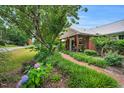 Charming brick pathway leads to a well-maintained home with lush greenery at 202 Hilltop Ave, Garner, NC 27529