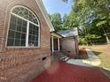 Side view of a brick house with landscaped yard and a charming entryway at 2032 Sherry Lynn Dr, Garner, NC 27529