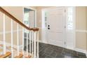 Welcoming entryway features slate floors, paneled door, and wooden staircase at 223 Shadowbrook Dr, Burlington, NC 27215