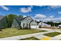 Gray two-story home with a three-car garage situated on a green lot at 2313 Abbeyhill Dr # 3, Raleigh, NC 27610
