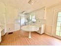 Bright eat-in kitchen features white cabinets and laminate wood flooring at 3716 Rivermont Rd, Durham, NC 27712
