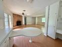 Spacious living area featuring laminate floors and a cozy brick fireplace at 3716 Rivermont Rd, Durham, NC 27712