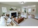 Bright living room with fireplace, neutral furniture, and an adjacent dining area at 3804 Cobb St, Garner, NC 27529