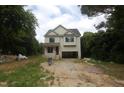 Two-story house with light siding, an attached garage, and a covered entry surrounded by trees at 4109 Stonewall Dr, Raleigh, NC 27604