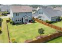 Aerial view of a spacious backyard with a well-kept lawn and a charming wood fence at 42 Village Walk Dr, Chapel Hill, NC 27517