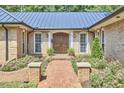 Welcoming front entrance featuring a brick walkway, manicured landscaping, and a stylish front door at 423 N Cameron St, Hillsborough, NC 27278