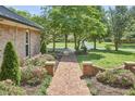 Brick walkway leading to the home, surrounded by lush landscaping and mature trees at 423 N Cameron St, Hillsborough, NC 27278