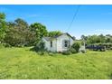 Cozy cottage home with white siding, a front porch, and a green lawn at 441 Cedar St, Henderson, NC 27536