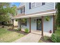 Inviting front porch with rustic wooden columns, hanging plants, and a welcoming wreath on the front door at 4520 Timberhurst Dr, Raleigh, NC 27612