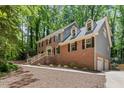 Charming brick home featuring dormer windows, a two-car garage and a well-kept lawn at 5125 Penny Rd, Raleigh, NC 27606