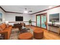 Inviting living room with hardwood floors, neutral walls, a plush orange sofa, and large glass doors to screened porch at 5125 Penny Rd, Raleigh, NC 27606