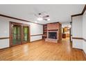 Cozy living room featuring wood floors, a brick fireplace, and glass doors leading to the outside at 5125 Penny Rd, Raleigh, NC 27606