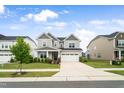 Charming two-story home showcasing a two-car garage, lush landscaping, and inviting curb appeal at 5420 Mill Dam Rd, Wake Forest, NC 27587