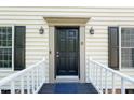 Inviting front door with sidelights, framed by a porch, and enhanced with decorative lanterns at 6 Weathergreen Ct, Durham, NC 27713