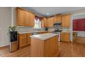 Spacious kitchen with wood cabinets, island, stainless steel appliances, and hardwood flooring at 708 Cheselden Dr, Durham, NC 27713