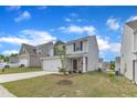 Suburban home featuring vinyl siding, stone accents, a well-manicured lawn, and a paved driveway at 717 Little Patch St, Zebulon, NC 27597