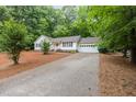 Inviting single-Gathering home featuring an attached garage, red front door and a long driveway at 790 Cashmere Ct, Sanford, NC 27332