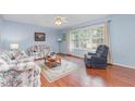 Comfortable living room featuring a floral sofa, area rug, and large window at 790 Cashmere Ct, Sanford, NC 27332