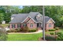 An elevated view of a stunning brick home nestled among lush greenery at 7932 Twin Pines Way, Fuquay Varina, NC 27526