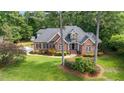 Aerial view of a brick home surrounded by a well-maintained lawn and mature trees at 7932 Twin Pines Way, Fuquay Varina, NC 27526