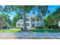 Beautiful two-story home featuring a lush green lawn, mature trees and a classic white picket fence at 8042 Hogan Dr, Wake Forest, NC 27587