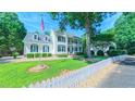 Inviting home exterior with an American flag, green lawn, and white picket fence offering timeless charm at 8042 Hogan Dr, Wake Forest, NC 27587