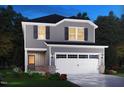 Charming two-story home with gray siding, black shutters, a two-car garage, and colorful landscaping at 845 Ottawa Dr, Garner, NC 27529
